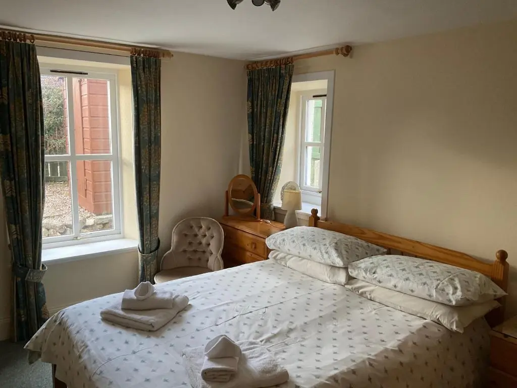 a bedroom with a bed with towels on it at Three-Bedroom Old Cottage Free Parking in Inverness
