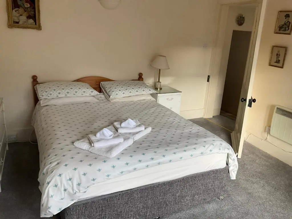 a bedroom with a bed with two towels on it at Three-Bedroom Old Cottage Free Parking in Inverness