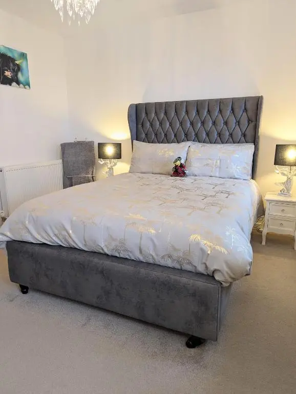 a bed with a teddy bear sitting on top of it at Seaesta Apartments in Macduff