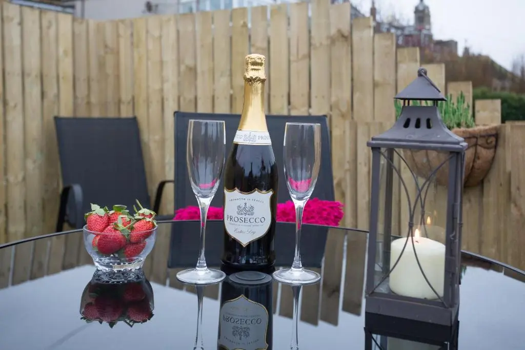 a bottle of wine and two wine glasses on a table at Seaesta Apartments in Macduff