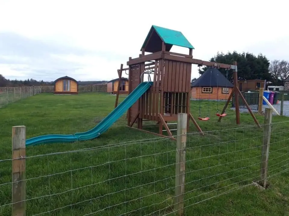 a playground with a slide and a tower at Greencraig Pods in Buckie