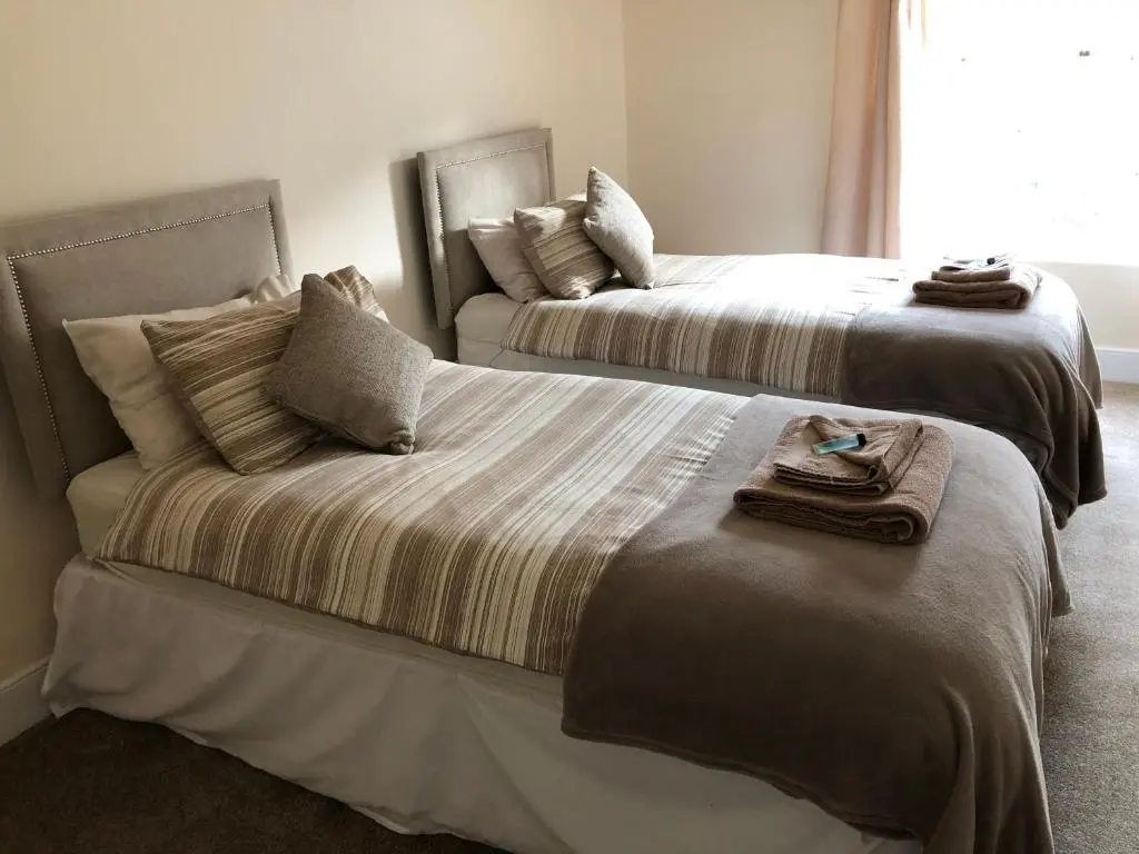 two beds sitting next to each other in a room at River Cottage in Inverness
