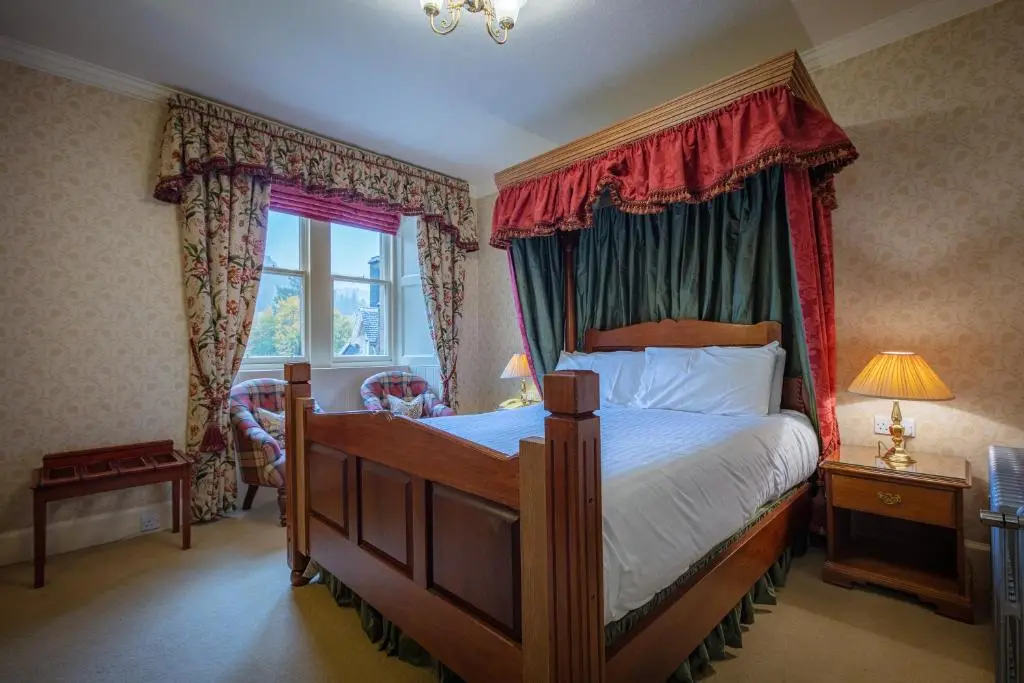a bedroom with a bed with a canopy at Glengarry Castle Hotel in Invergarry