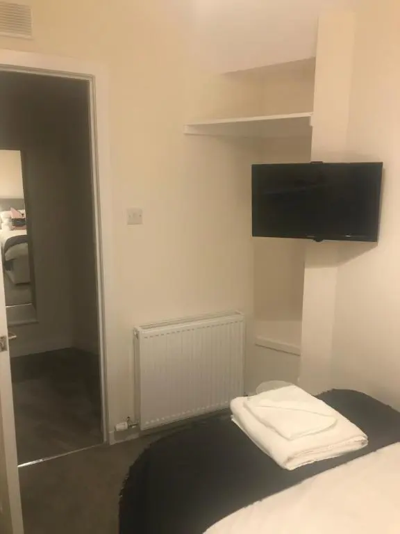 a room with a bed with a tv on the wall at 2 Lower Kessock Street in Inverness
