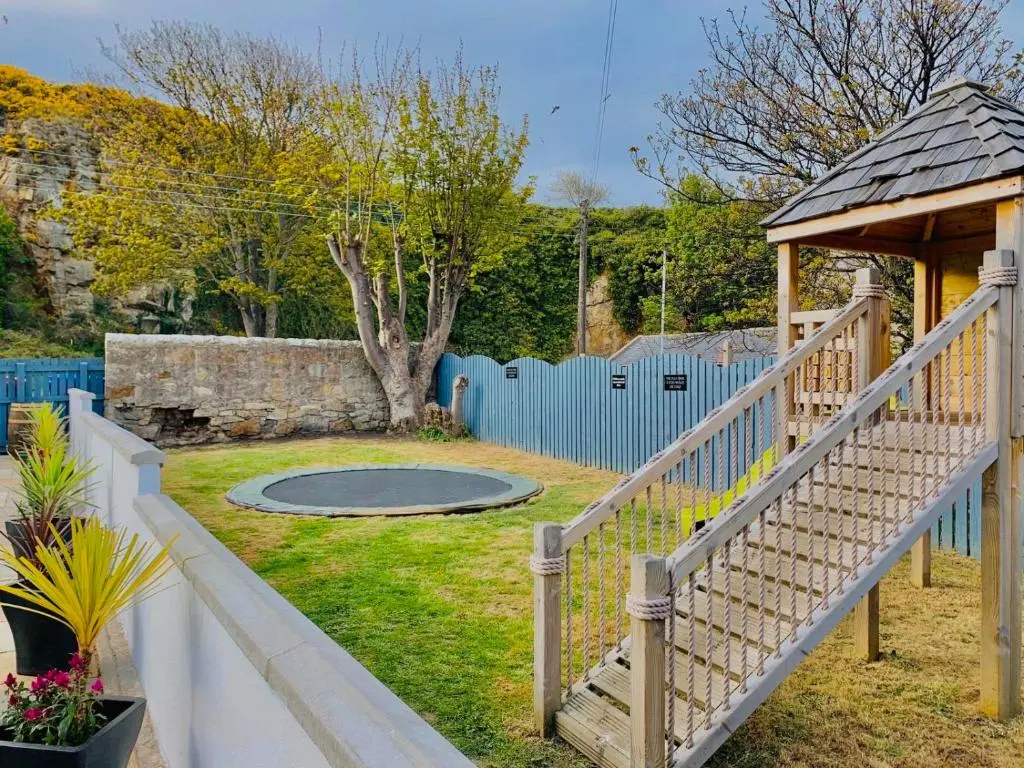a wooden stairway leading to a playground with a blue fence at Firth Hotel & Restaurant in Lossiemouth