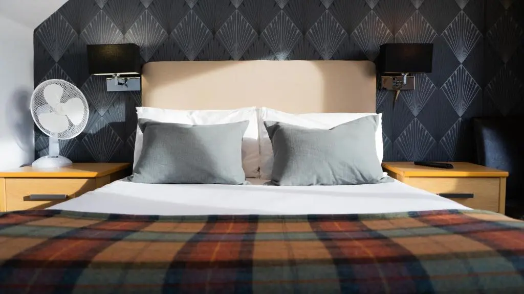 a bedroom with a bed with pillows and a blanket at Firth Hotel & Restaurant in Lossiemouth