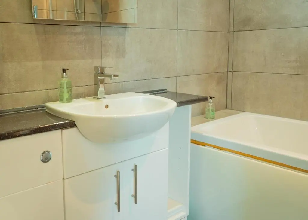 a bathroom with a white sink and a tub at Firth Hotel & Restaurant in Lossiemouth