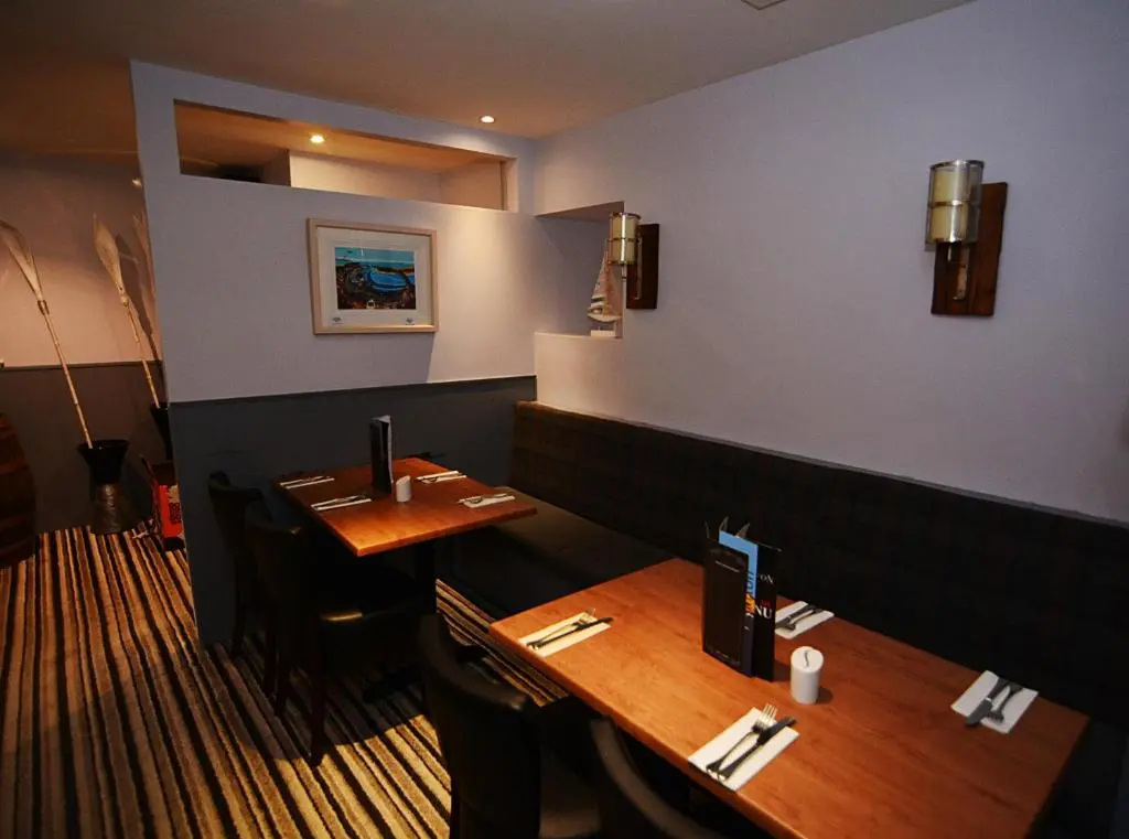 a dining room with two tables in a restaurant at Firth Hotel & Restaurant in Lossiemouth