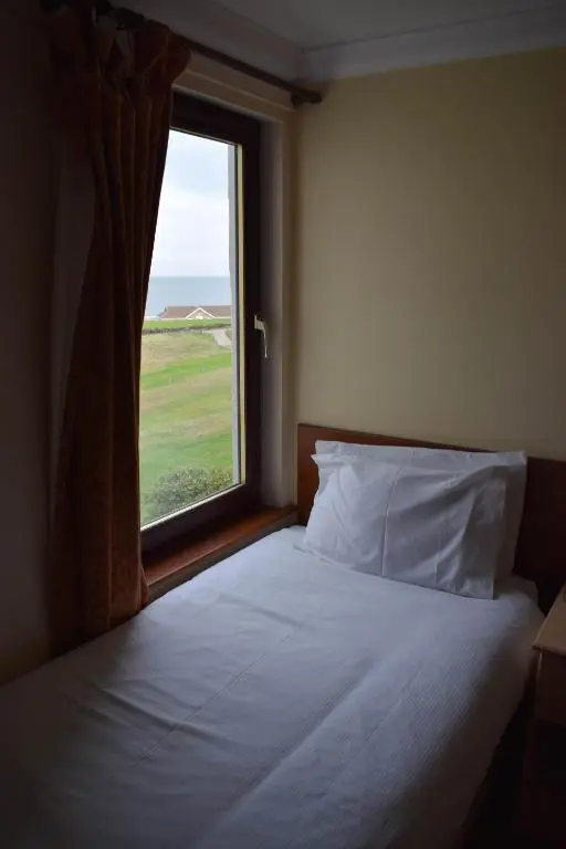 a bedroom with a bed with a large window at GOLF View Hotel & Macintosh Restaurant in Lossiemouth