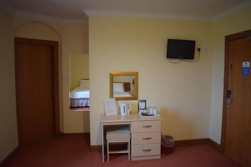 a hotel room with a desk and a bed at GOLF View Hotel & Macintosh Restaurant in Lossiemouth