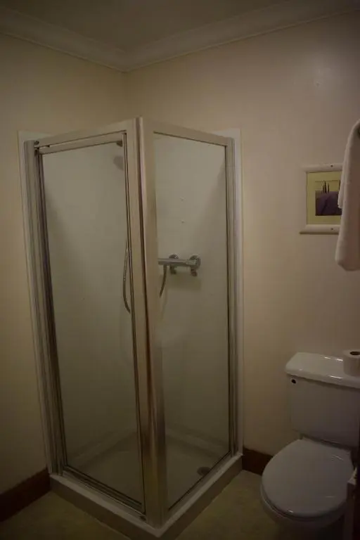 a shower stall in a bathroom with a toilet at GOLF View Hotel & Macintosh Restaurant in Lossiemouth