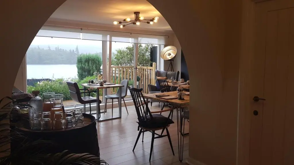 a dining room with tables and chairs and a large window at Airanloch Bed & Breakfast,Loch Ness, Adult Only in Lochend
