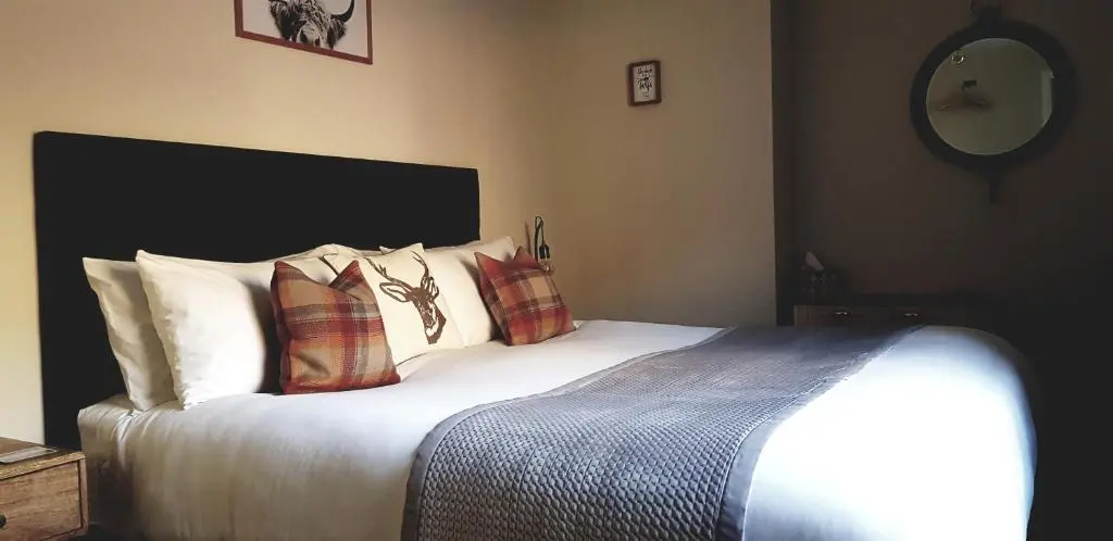 a bedroom with a large bed with pillows on it at Airanloch Bed & Breakfast,Loch Ness, Adult Only in Lochend