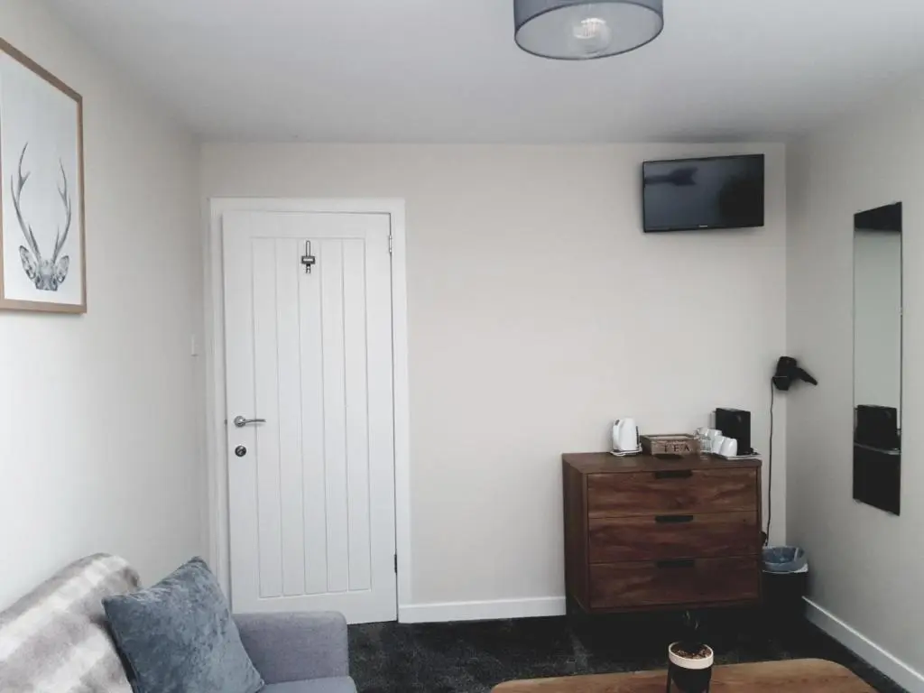 a living room with a couch and a tv at Airanloch Bed & Breakfast,Loch Ness, Adult Only in Lochend