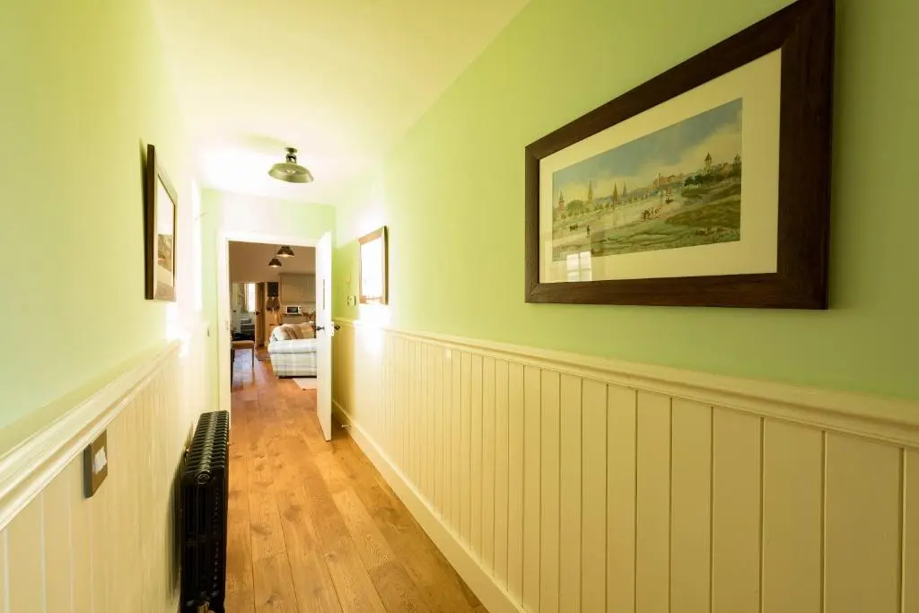 a hallway of a home with a painting on the wall at Evelix, The Old School House in Muir of Ord