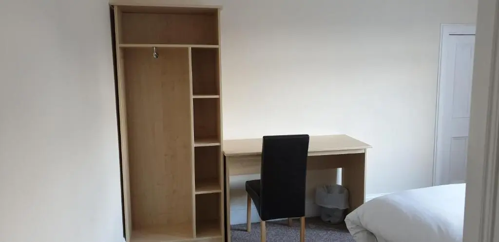 a bedroom with a desk and a chair next to a bed at SPRINGBANK Holiday Home in Inverness