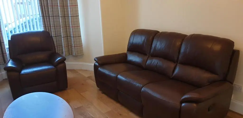 a living room with a leather couch and a chair at SPRINGBANK Holiday Home in Inverness