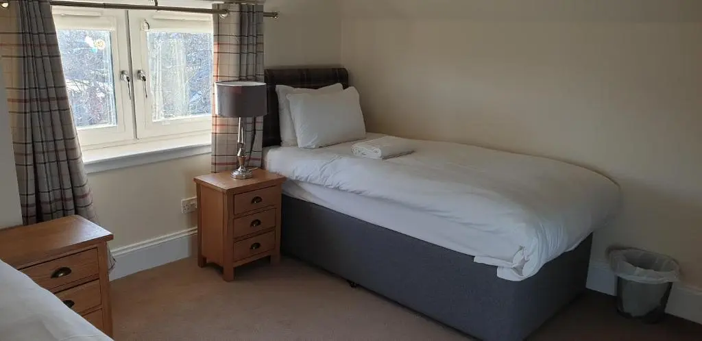 a small bedroom with a bed and a window at SPRINGBANK Holiday Home in Inverness