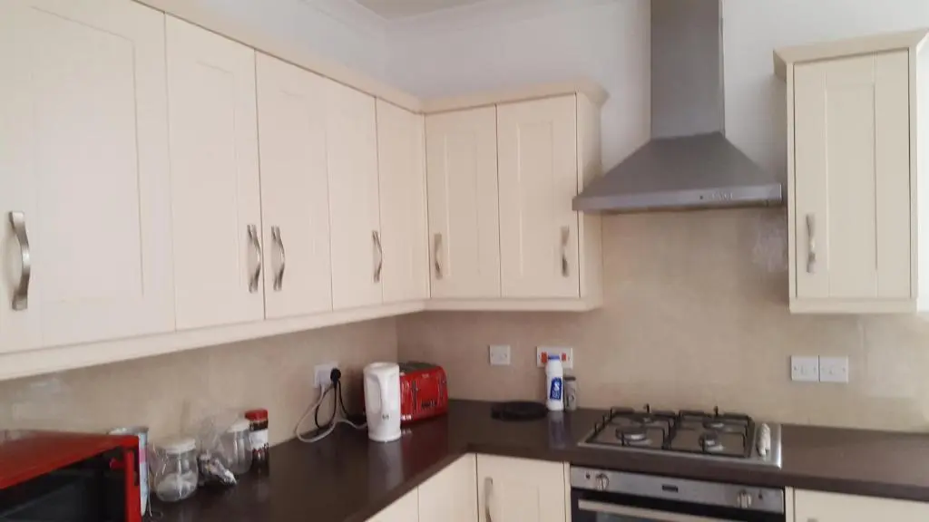 a kitchen with white cabinets and a stove top oven at SPRINGBANK Holiday Home in Inverness