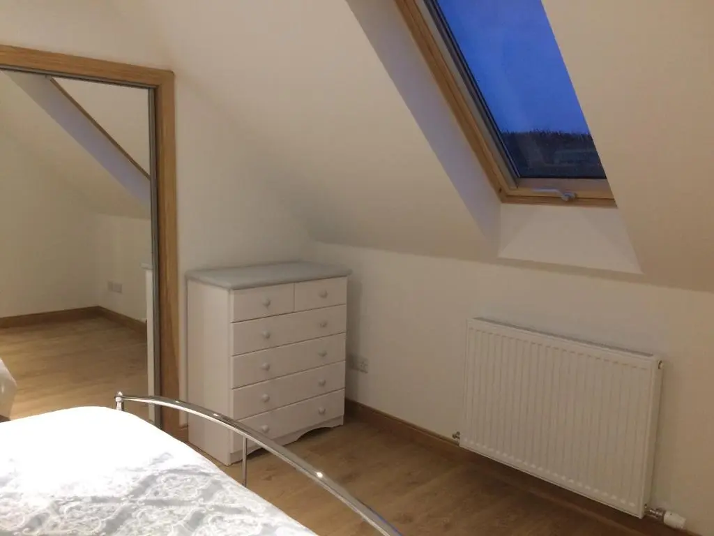 a bedroom with a skylight and a bed and a dresser at LAIRDS COTTAGE in Stuartfield