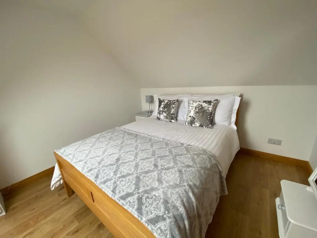 a bedroom with a large bed with pillows on it at LAIRDS COTTAGE in Stuartfield