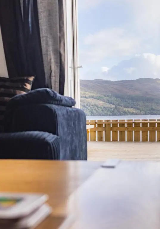 a living room with a couch and a large window at Loch Ness Cottage in Fort Augustus