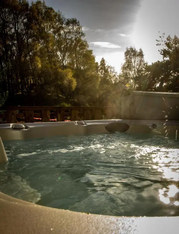 a hot tub with water in it in a yard at Lagganlia Lodges and Camping Pods in Kincraig