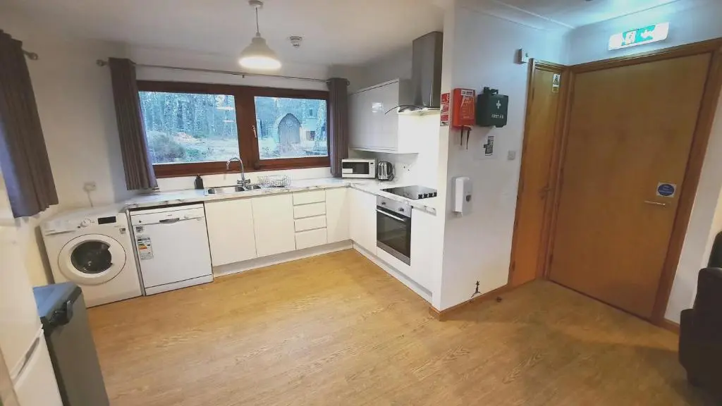 a kitchen with a sink and a washing machine at Lagganlia Lodges and Camping Pods in Kincraig