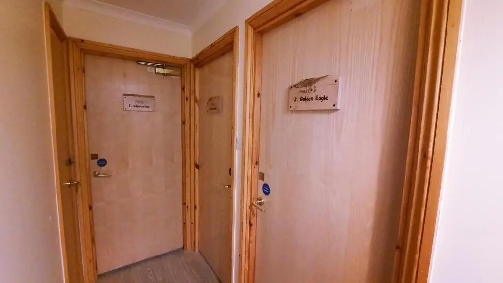 a hallway with a door with a sign on it at Lagganlia Lodges and Camping Pods in Kincraig
