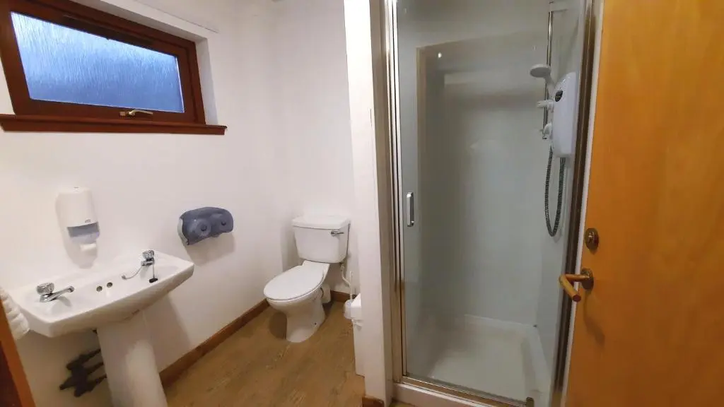 a bathroom with a toilet and a sink and a shower at Lagganlia Lodges and Camping Pods in Kincraig