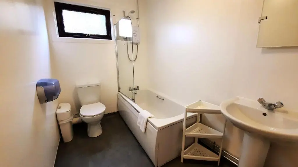 a bathroom with a tub and a toilet and a sink at Lagganlia Lodges and Camping Pods in Kincraig