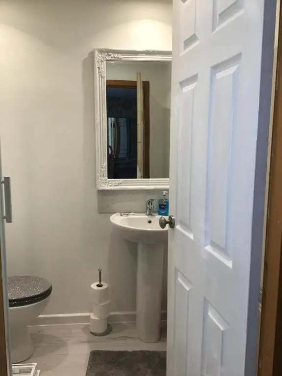 a white bathroom with a sink and a mirror at No.9 in Inverness