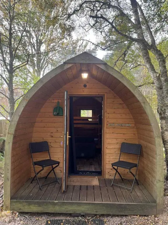 two chairs are sitting in a small wooden house at Pine Marten Bar Glenmore Pods in Aviemore