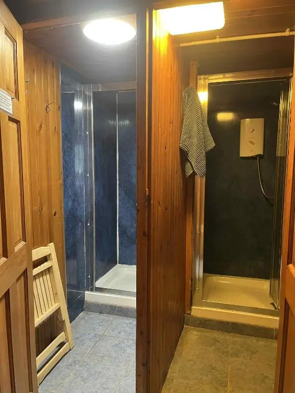 a bathroom with a shower with a glass door at Pine Marten Bar Glenmore Pods in Aviemore