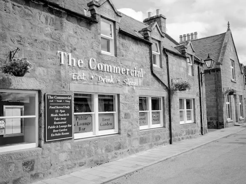 a black and white photo of an old brick building at The Commercial Hotel in Tarland