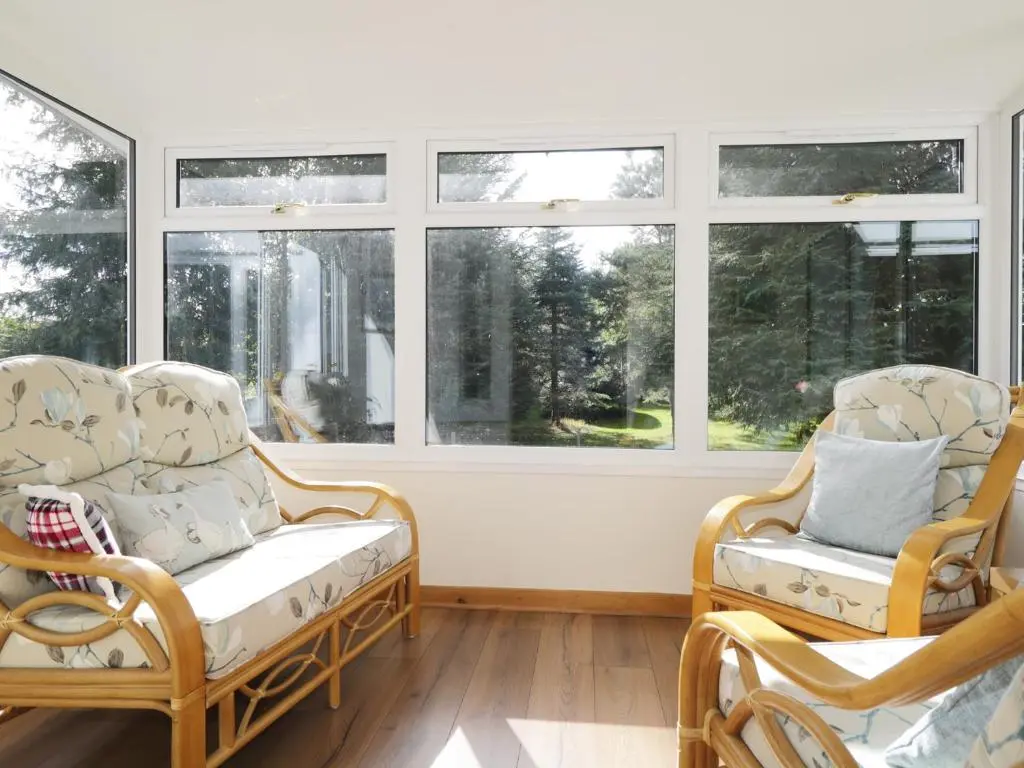 a living room with two chairs and windows at St Aethans in Inveran
