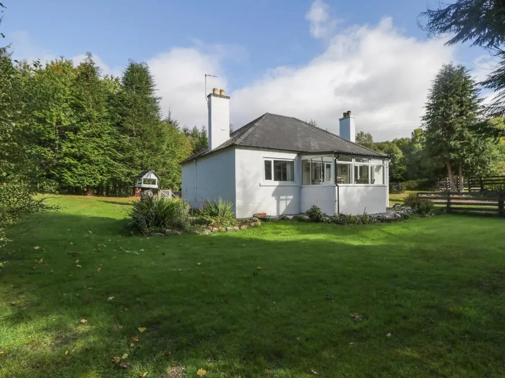 a white house with two chimneys on a yard at St Aethans in Inveran
