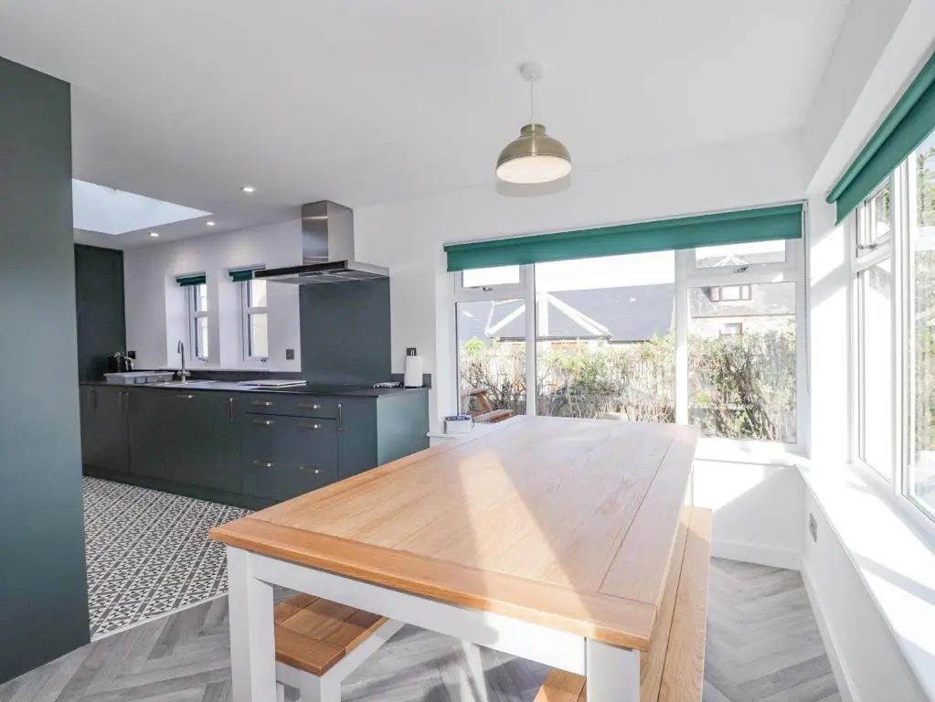 a kitchen with a wooden table and a large window at 19 Reidhaven Street in Banff