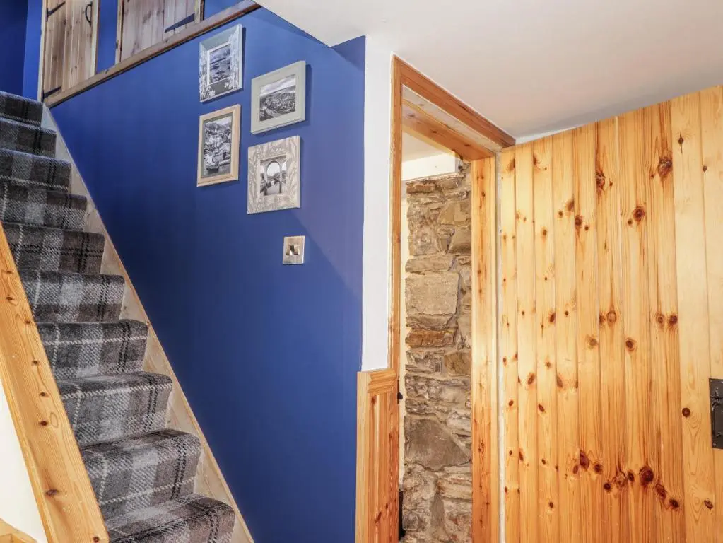 a blue wall with pictures on it next to a staircase at 83 Seatown in Buckie