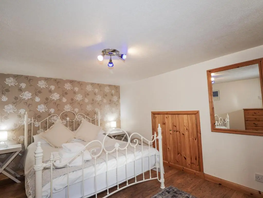 a bedroom with a white bed and a mirror at 83 Seatown in Buckie