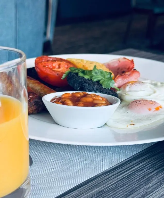 a plate of breakfast food on a table with a glass of orange juice at Star Hotel Kingussie in Kingussie