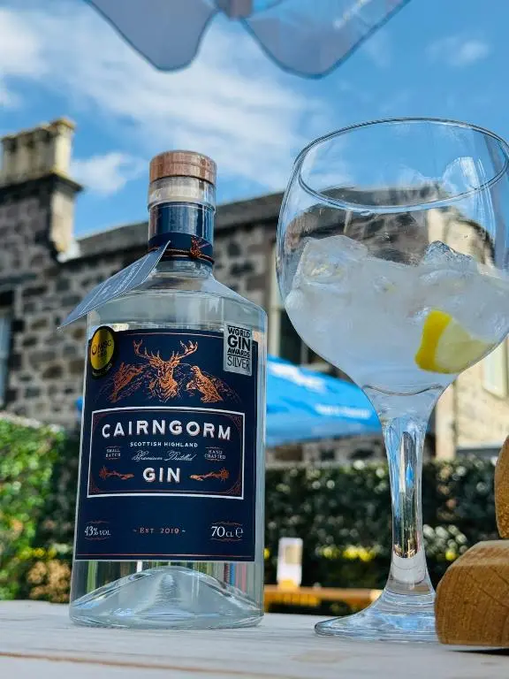 a bottle of gin sitting next to a glass at Star Hotel Kingussie in Kingussie