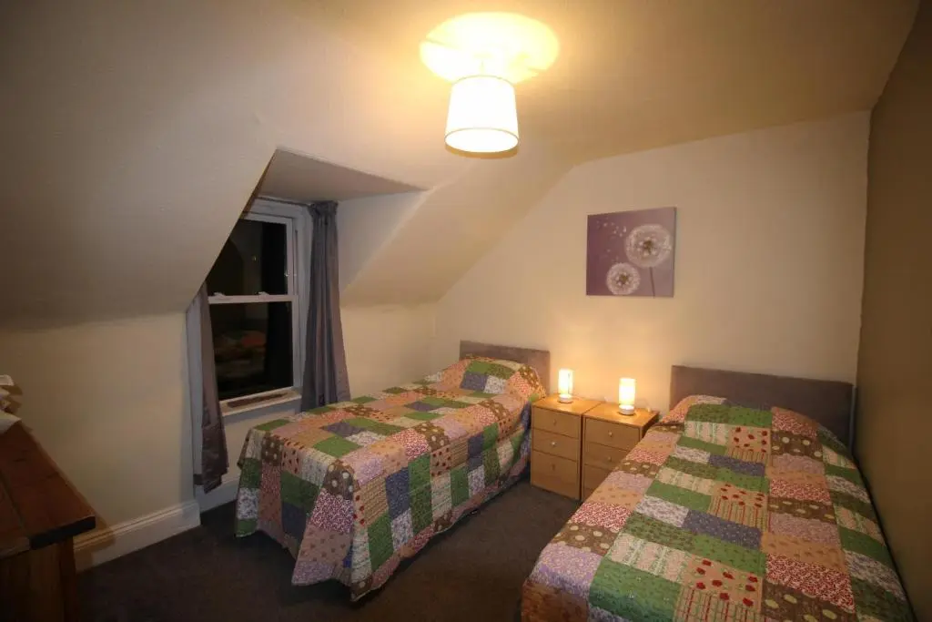 a hotel room with two beds and a window at 63 Argyle Street in Inverness