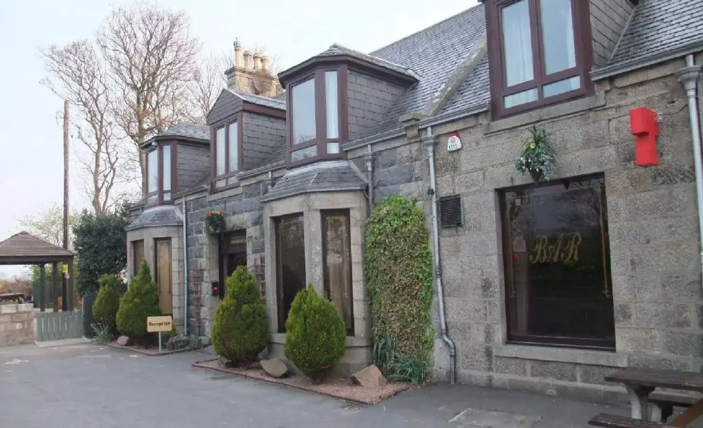 a brick house with a store front at Ban Car Hotel in Cairness