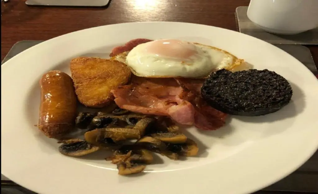 a plate of breakfast food with an egg on top at Ban Car Hotel in Cairness