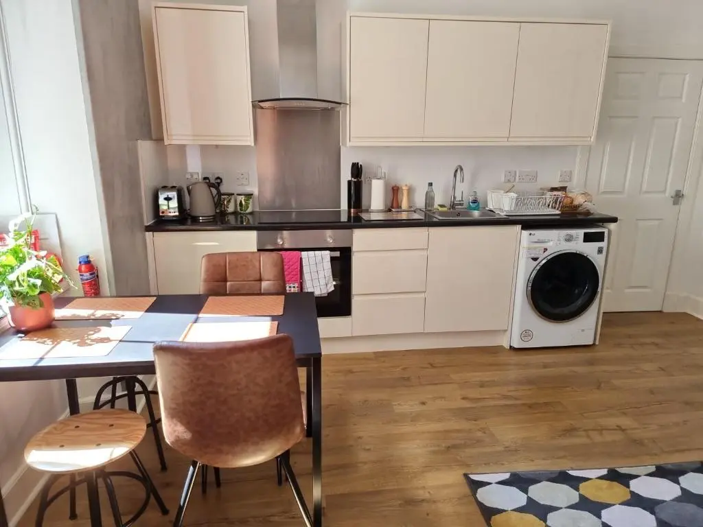 a kitchen with a table and a washing machine at CHARMING VICTORIAN APARTMENT, close to centre in Inverness