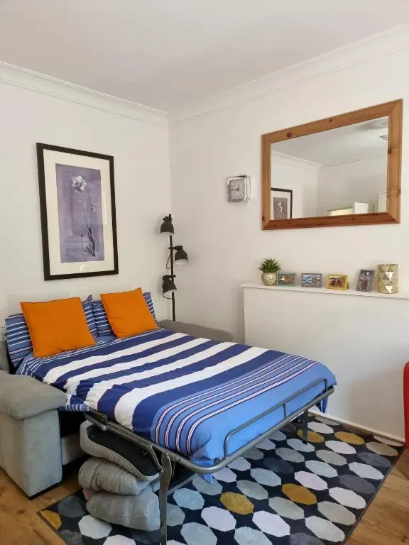 a bed in a room with a mirror on the wall at CHARMING VICTORIAN APARTMENT, close to centre in Inverness