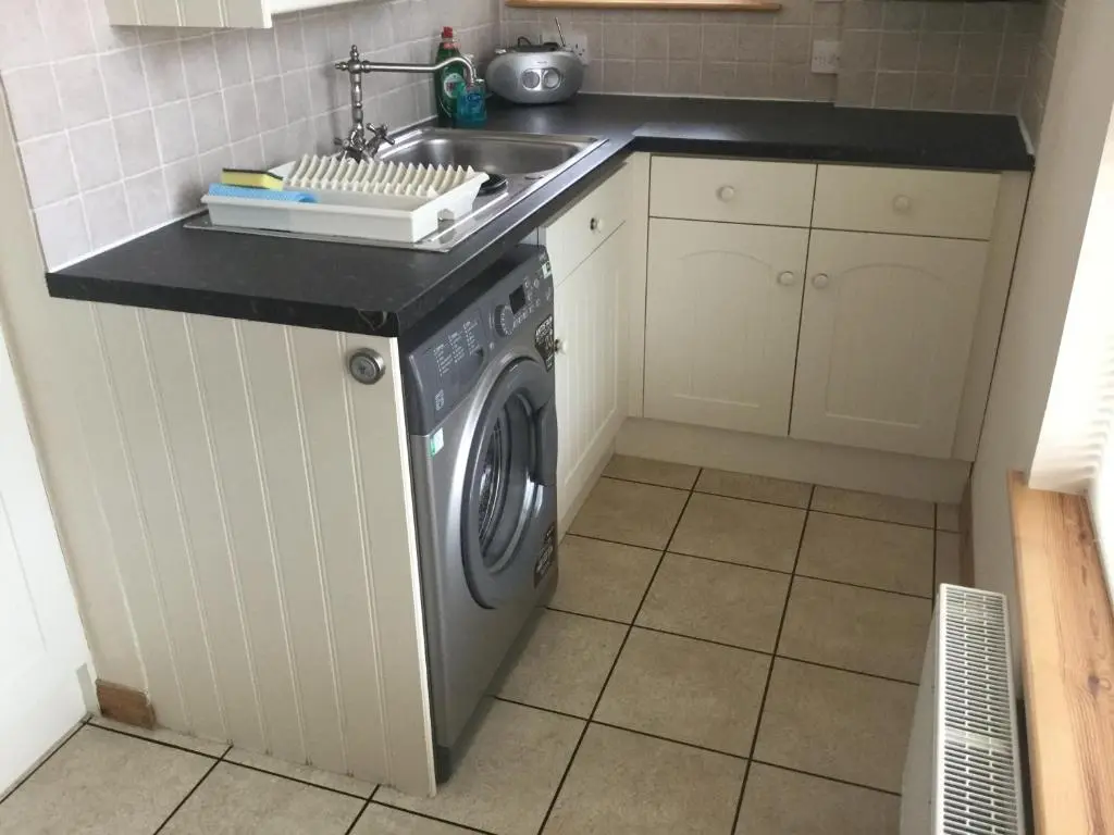 a kitchen with a washing machine and a sink at New Cottage 3 Bedroom Free Parking in Inverness