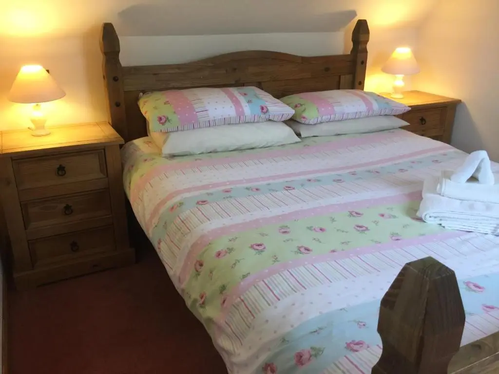 a bedroom with a bed with two night stands at New Cottage 3 Bedroom Free Parking in Inverness