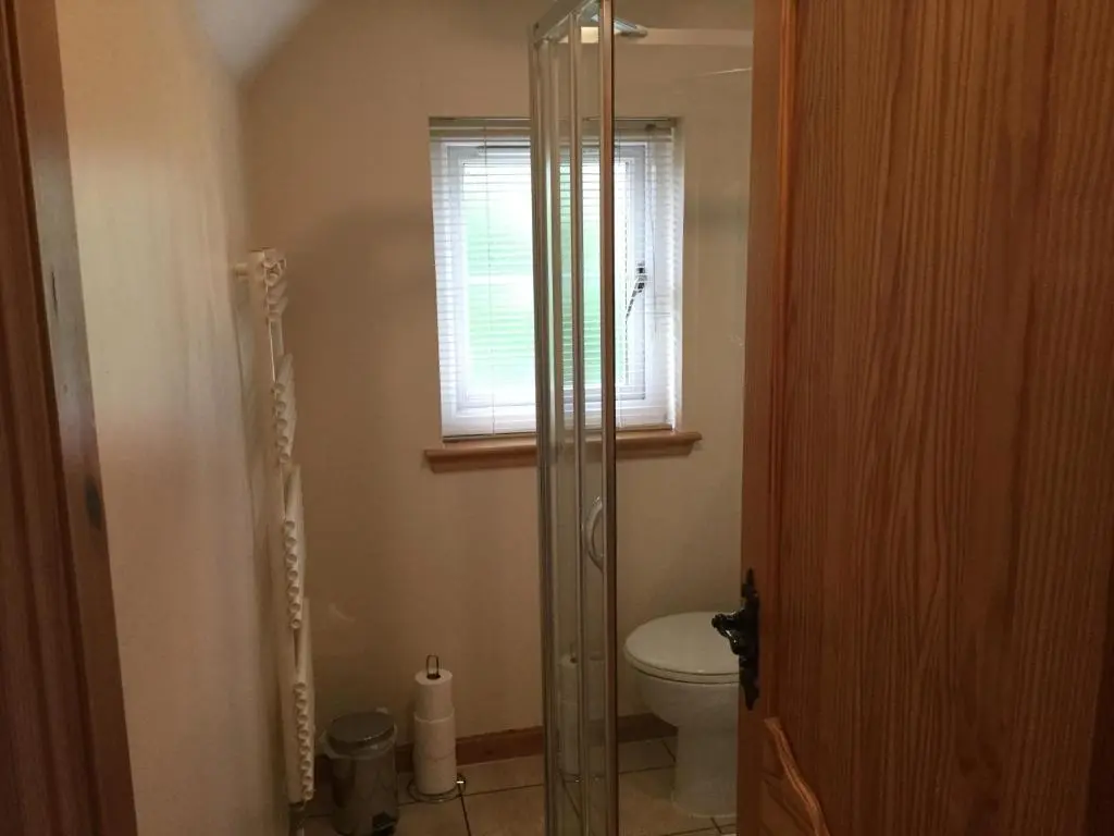 a bathroom with a toilet and a glass shower at New Cottage 3 Bedroom Free Parking in Inverness